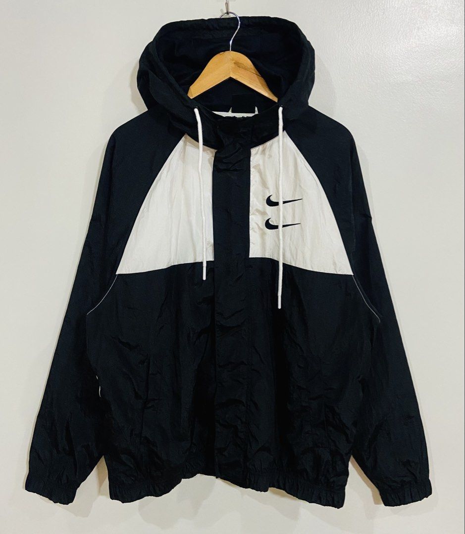 Nike Swoosh International Windbreaker Jacket (Category: Coats, Jackets and Outerwear) located in Manila. Submitted by thriftnijuan08 (Listing ID 1461338943, Image 2). Description: - Black and white Nike windbreaker jacket - Iconic Swoosh logo and 'Nike International' text on the back - Features a hood with adjustable drawstrings - Size: Large (L) - Made in Vietnam -Dimes 25/28.