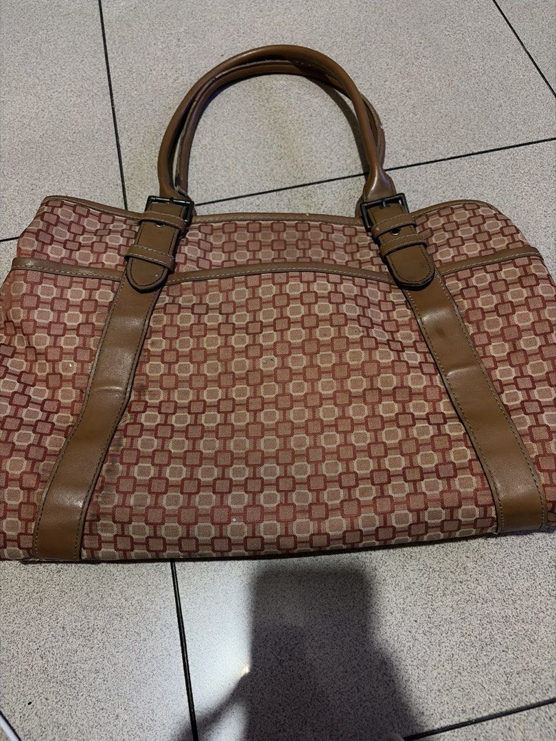 Nine West Monogrammed Tote Bag (Category: Tote Bags) located in Las Pinas. Submitted by ces0427 (Listing ID 1461344838, Image 1). Description: - Classic Nine West tote bag - Iconic monogram pattern - Rich brown and tan colorway - Genuine leather trim and handles - Spacious interior with multiple compartments - Includes zippered pockets for security - Ideal for everyday essentials or travel needs.