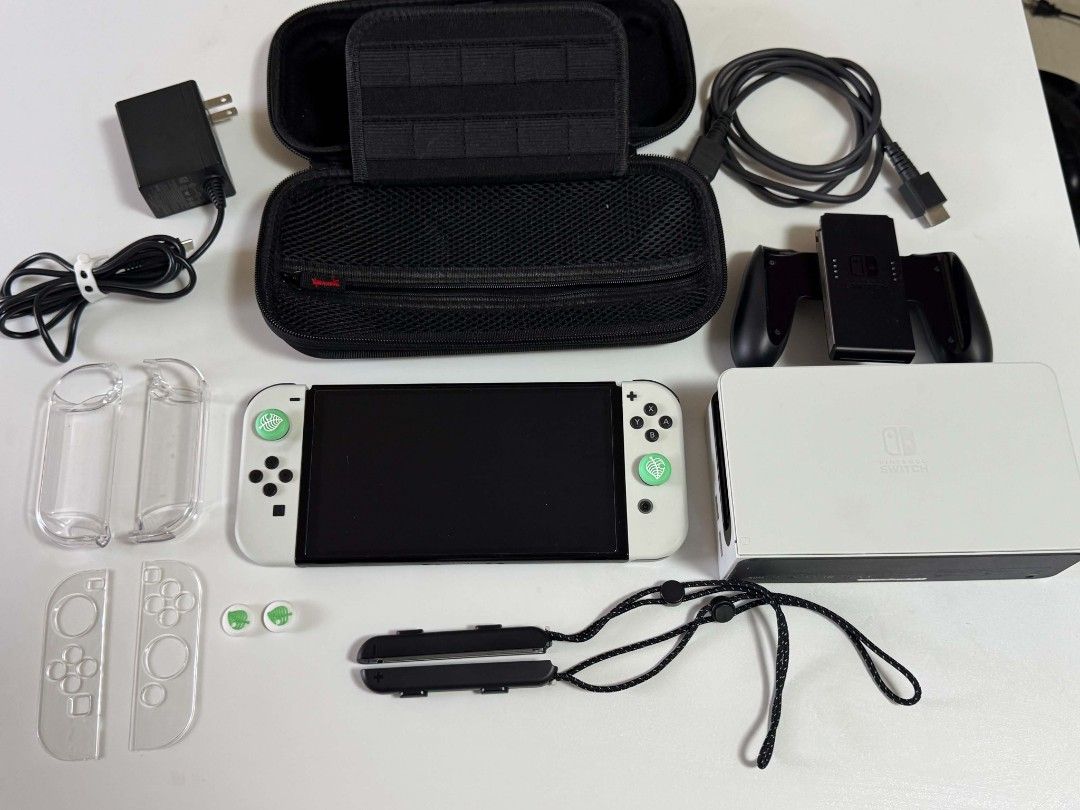 Nintendo Switch OLED (Pristine Condition) (Category: Nintendo) located in Manila. Submitted by trueowl.24db90 (Listing ID 1461371918, Image 1). Description: Pristine condition - rarely used Complete accessories - 2 Joycons (White) - Joycon protective case - 2 joycon strap - 1 joycon charging grip - 4 thumb grip - installed screen protector - 1 dock - 1 HDMI Cable - 1 Charger - Hard Case SLIGHTLY NEGOTIABLE Testing prior and upon meetup Meetup aro