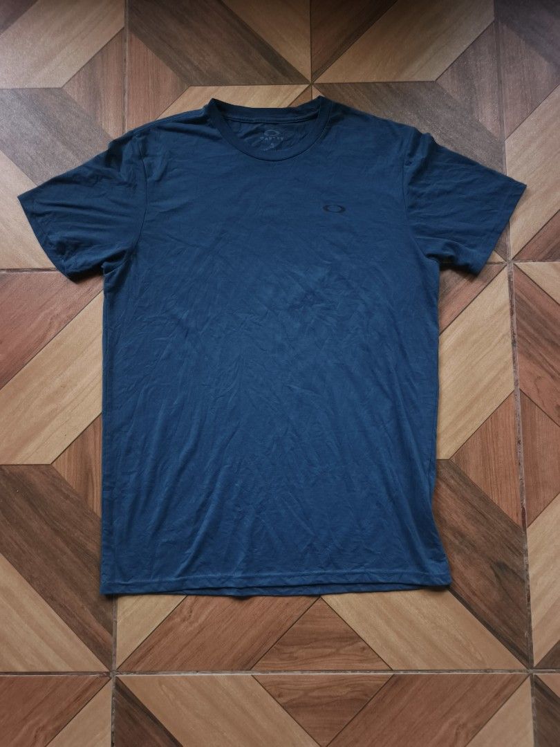 Oakley Basic Logo Tee (Category: Tshirts & Polo Shirts ) located in Zamboanga. Submitted by d2977250664046 (Listing ID 1461478414, Image 1). Description: - Brand: Oakley - Color: Dark Teal - Size: L 21x29 dimes - Fit: Regular - Material: 85% Polyester, 15% Cotton - Origin: Made in Honduras - Features: Oakley logo on chest - Ideal for: Casual wear - No Flaws (NeedWash).