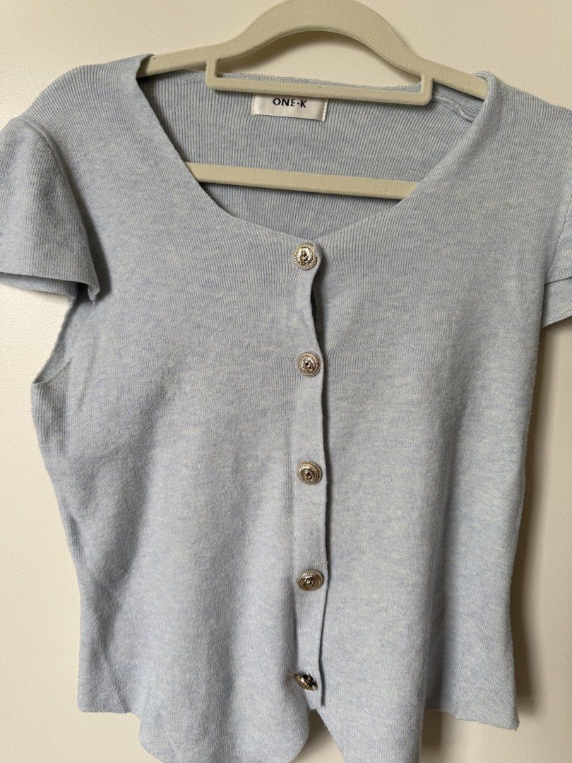ONE-K Light Blue Button-Up Short Sleeve Cardigan (Category: Coats, Jackets and Outerwear) located in Pasig City. Submitted by yensyard__ (Listing ID 1461381316, Image 3). Description: - xs-s frame - Light blue short sleeve cardigan - Brand: ONE-K - V-neckline - Button-up front with silver button details - Ribbed knit material - Versatile for layering with jeans or skirts.