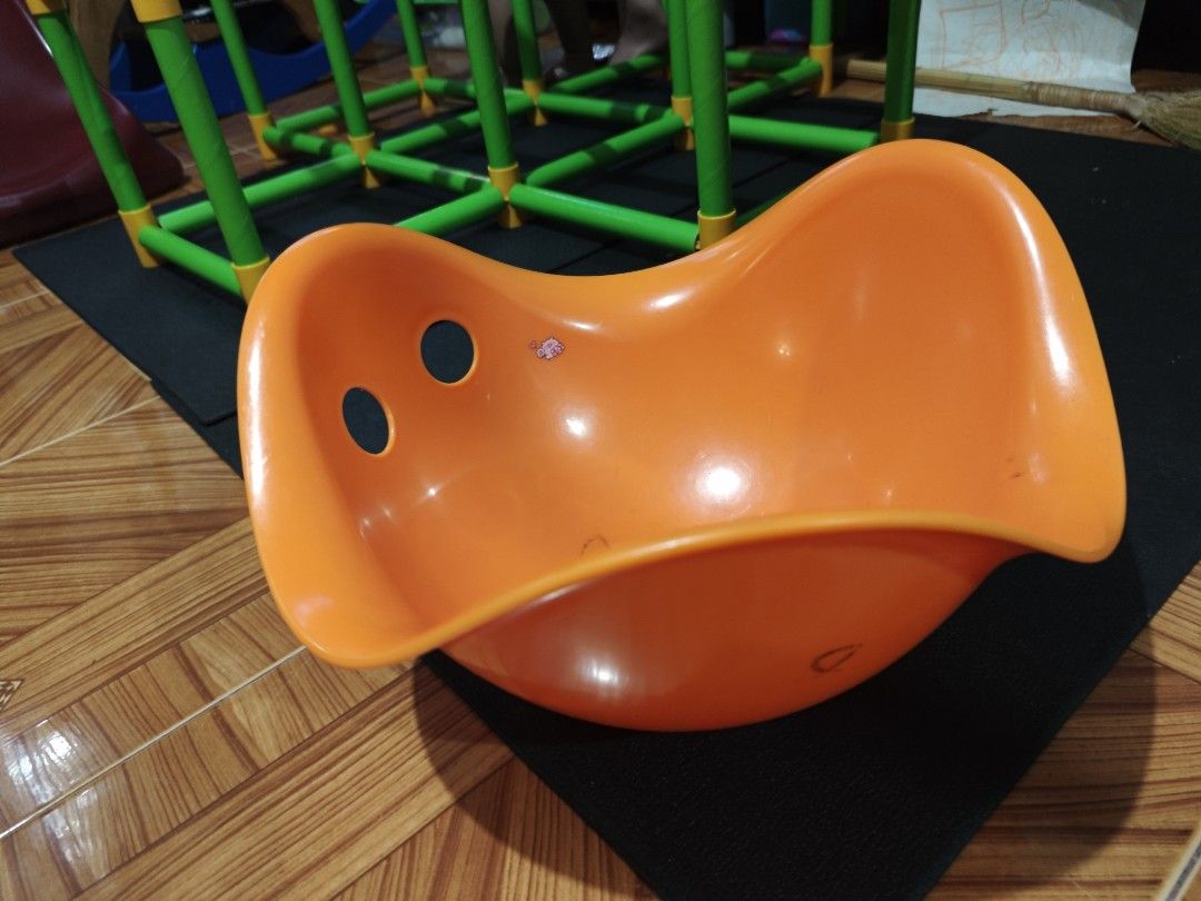Orange Rocker Seat for Kids (Category: Kids Tables & Chairs) located in Quezon City. Submitted by jonandwhale (Listing ID 1461431827, Image 1). Description: - Orange rocker seat for children - Features two holes on the front - Ideal for indoor play - Shows minor scuffs from previous use - Ready for its next adventure!.