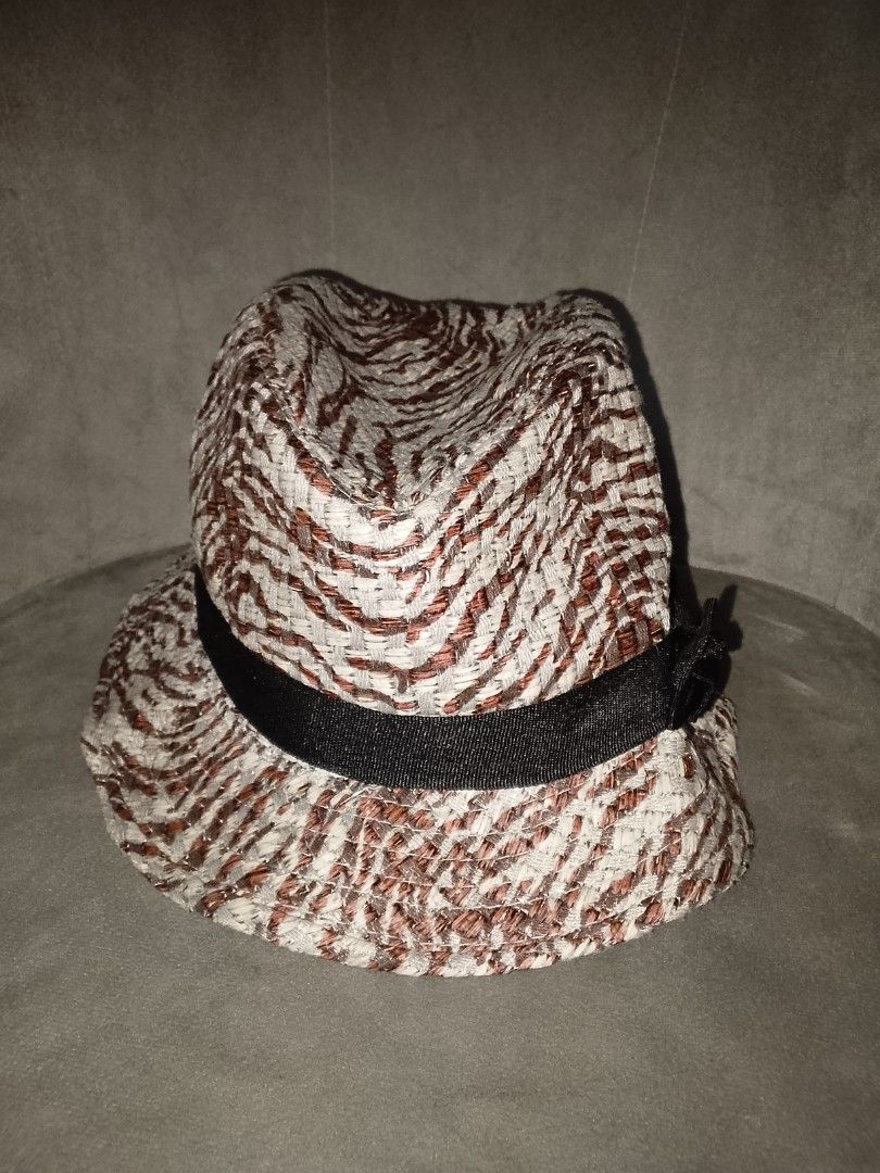 Patterned Straw Fedora Hat with Black Ribbon Bow (Category: Hats & Beanies) located in Binangonan. Submitted by yuristalin888 (Listing ID 1461381599, Image 2). Description: Add a chic, textured flair to your sunny-day wardrobe with this patterned straw fedora. Featuring a stylish interwoven design in earthy brown and cream tones, accented by a classic black ribbon band and a delicate side bow, this lightweight hat delivers a sophisticated twist o