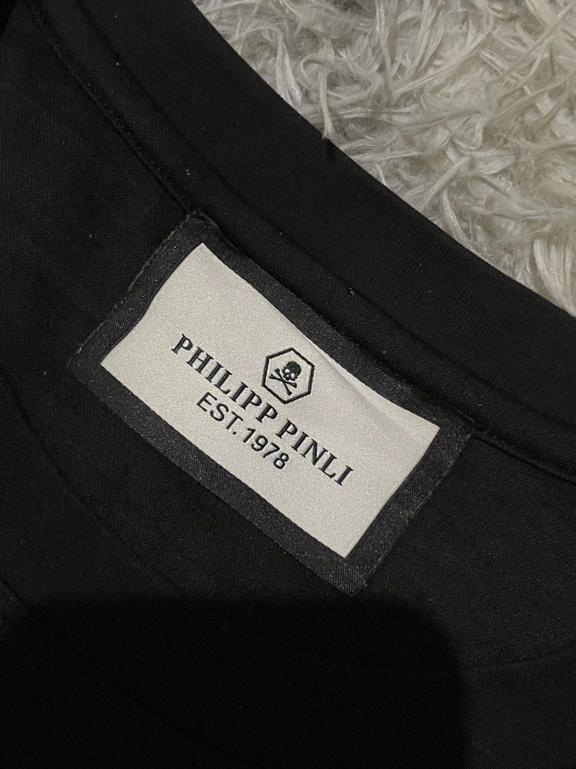 Philipp Plein Black T-Shirt with Hexagonal Logo (Category: Tshirts & Polo Shirts ) located in Manila. Submitted by khen23_408 (Listing ID 1461544962, Image 2). Description: - Authentic Philipp Plein black t-shirt - Size 56 - Iconic hexagonal PP logo with silver embellishments - Comfortable fabric - Ideal for casual wear or making a statement - Check label for material details.