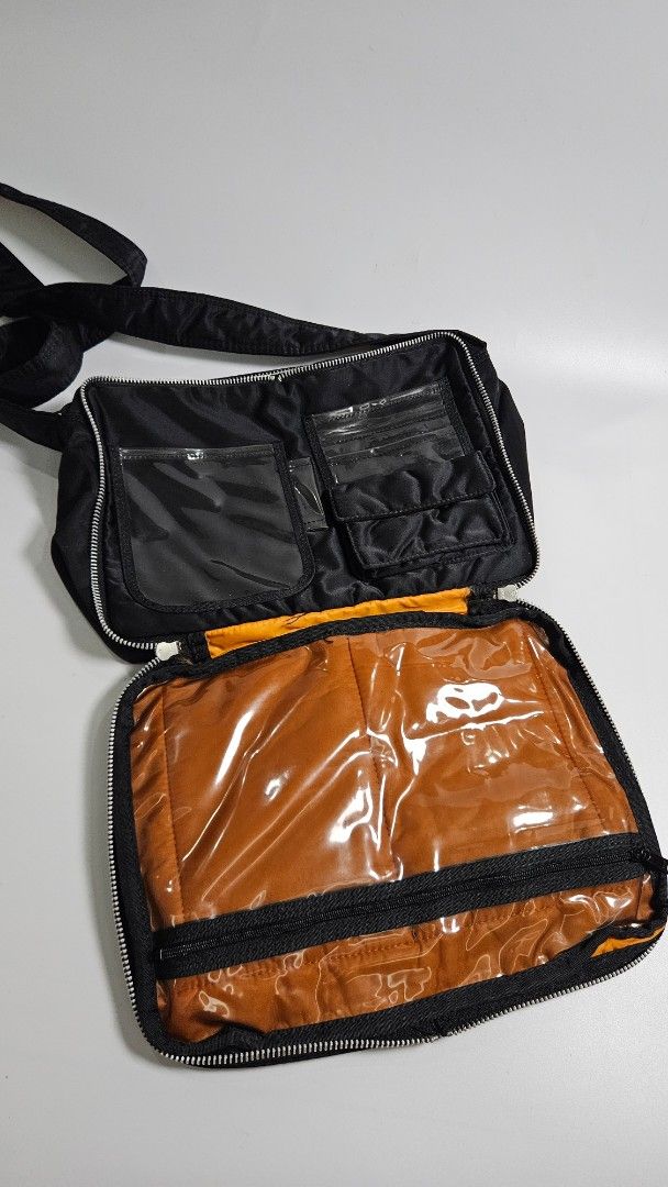 Porter Yoshida & Co. Tank Bag (Category: Sling Bags) located in Alfonso. Submitted by jbcamet (Listing ID 1461491496, Image 3). Description: - Durable black Porter shoulder bag - Made from tough nylon material - Multiple compartments for organized storage - Includes clear pockets and a main zippered section - Adjustable strap for comfortable carrying - Equipped with reliable YKK zippers - Ideal for everyday use or travel adventures.