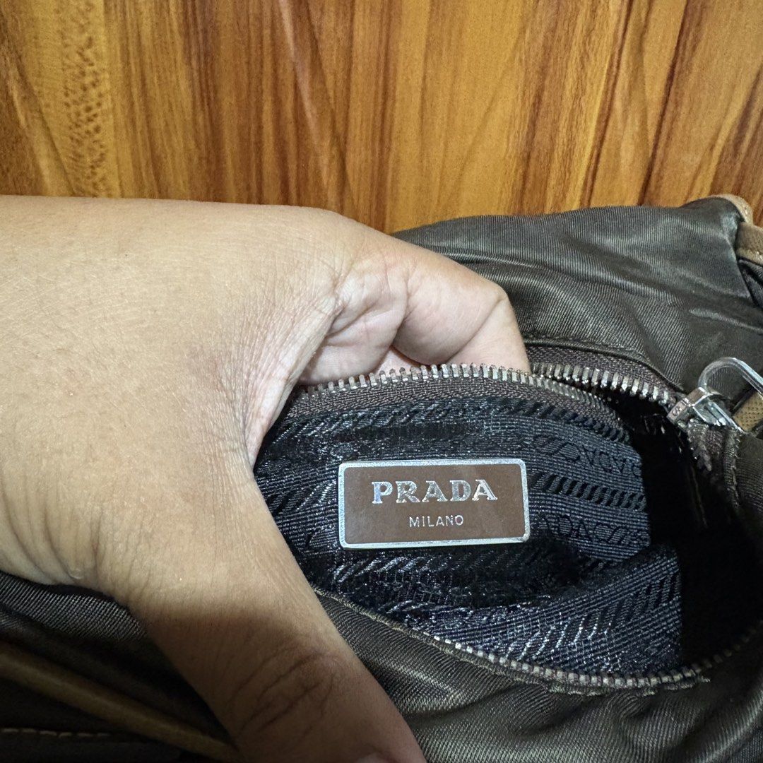 Prada Nylon Messenger Bag Khaki Brown (Category: Luxury Bags & Wallets) located in Carmen. Submitted by rr_thrifts (Listing ID 1461354280, Image 2). Description: - Prada messenger bag - Color: Khaki green nylon with brown leather trim - Features multiple compartments (inside and out) - Smooth working zippers - Adjustable strap for comfort - Ideal for everyday use - lampo zip - missing white tag - As is.