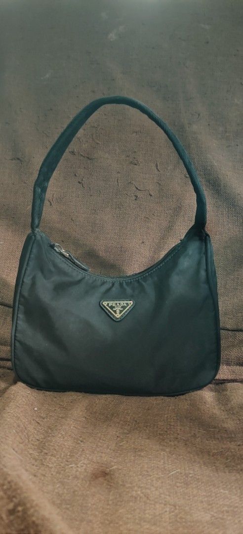 Prada Nylon Mini Hobo Shoulder Bag (Category: Luxury Bags & Wallets) located in Bago City. Submitted by louielinco (Listing ID 1461432876, Image 1). Description: - Authentic Prada shoulder bag - Black nylon material - Iconic Prada triangle logo - Zipper closure - Interior with Prada branding and 'Made in China' tag - Small size, ideal for essentials.