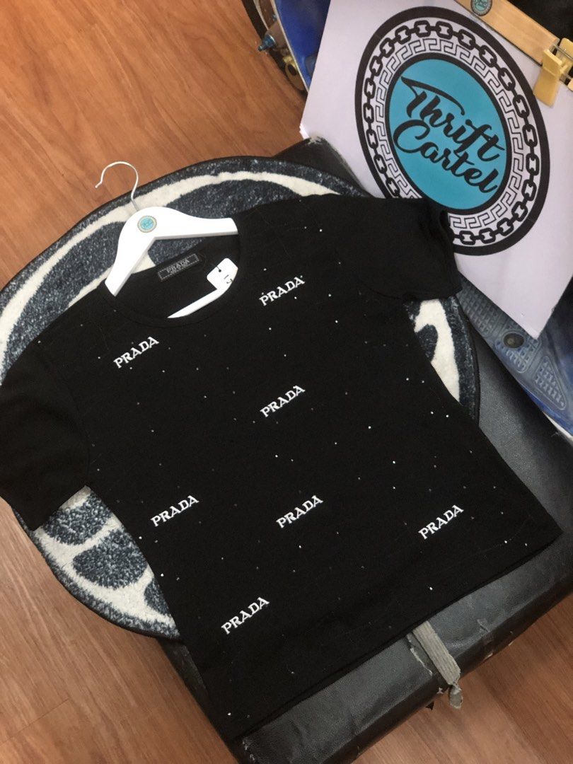 PRADA TEE (Category: Luxury Apparel) located in Baguio. Submitted by bilikabow (Listing ID 1461507086, Image 1). Description: PRADA black short-sleeve t-shirt accented with scattered rhinestones and repeated Prada logo prints. For her 17x20 .