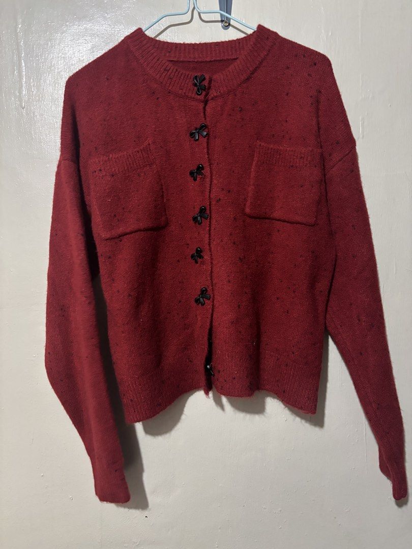 Red Speckled Button-Up Cardigan with Pockets (Category: Coats, Jackets and Outerwear) located in Caloocan City. Submitted by alnair7 (Listing ID 1461560362, Image 1). Description: - Adorable red cardigan with a unique speckled pattern. - Features charming black bow-shaped buttons down the front. - Two functional chest pockets for added detail. - Long sleeves with comfortable ribbed cuffs. - Ideal for stylish layering over your favorite outfits..