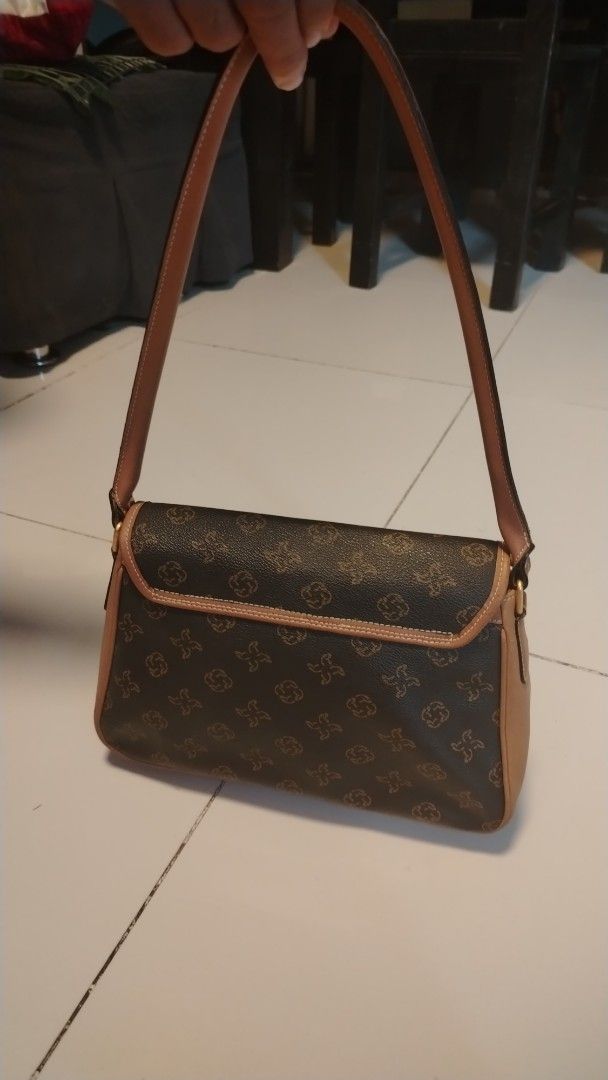 Renoir Monogram Shoulder Bag (Category: Luxury Bags & Wallets) located in Manila. Submitted by wildwind_73f77a (Listing ID 1461481521, Image 3). Description: - Brown shoulder bag with iconic Renoir monogram pattern. - Elegant tan leather trim and adjustable strap. - Secure flap closure with a magnetic snap. - Timeless baguette style, ideal for everyday wear. - Approximate dimensions: 10 inches wide by 6 inches tall..