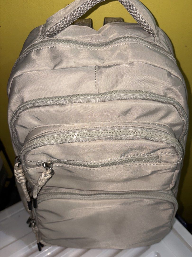 Light Beige Nylon Backpack with Multiple Zipped Pockets (Category: Backpacks) located in Manila. Submitted by cleverwater2528 (Listing ID 1461480880, Image 3). Description: - Light beige nylon backpack (with slight stain visible in the picture) - Main compartment - Front zipped pockets - Small top front zipped pocket - Adjustable straps with rope pull tabs - Ideal for everyday use or travel PRICE IS STILL NEGOTIABLE.