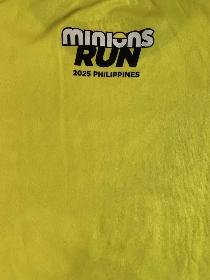 Running with the Minion Run (Category: Activewear) located in Taguig. Submitted by ahnjr (Listing ID 1461430711, Image 2). Description: - Product: "Running with the Minion Run" T-shirt - Size: S (EU 48/UK 38/US 38) - Color: Yellow - Design: Features "Running with the Minions" graphic and "Be Fast or Be Last" slogan on the front. - Event Detail: "Minions Run 2025 Philippines" printed on the back. - Meetup Location: Vista Mall Taguig, Cayetano Blvd