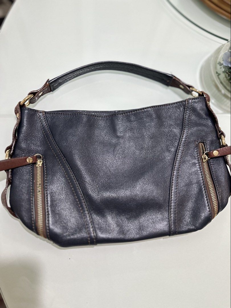 Sabrina Dark Blue Leather Shoulder Bag (Category: Shoulder Bags) located in Mandaluyong City. Submitted by TheWeekendProject (Listing ID 1461520426, Image 1). Description: - Stylish dark blue leather shoulder bag - Features elegant brown leather accents - Accented with shiny gold zippers - Can be worn as a shoulder bag or a crossbody (strap not included) - Offers ample interior space for your belongings - Ideal for everyday use and carrying your 