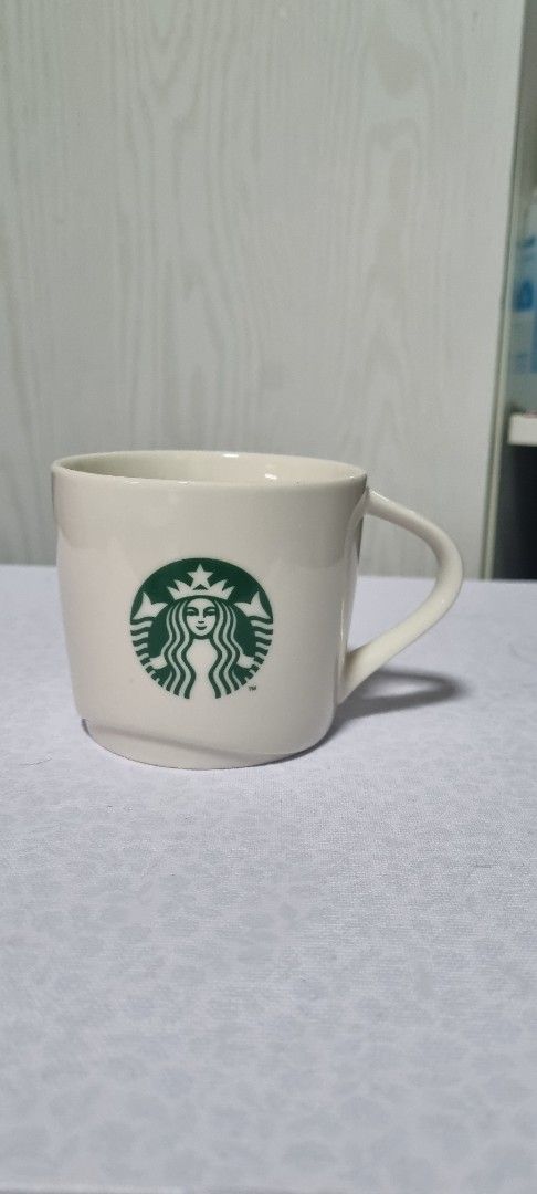 Starbucks White Mug with Green Logo (Category: Coffee & Tea Tableware) located in Manila. Submitted by ags028705 (Listing ID 1461561365, Image 1). Description: - Classic white Starbucks mug - Features the iconic green siren logo - Ideal for morning coffee or tea - Sturdy ceramic build - Perfect size for everyday use - Simple and timeless design.