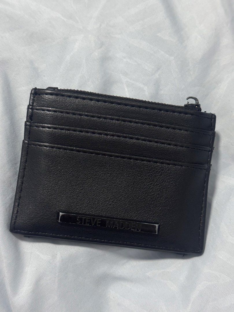 Steve Madden Black Card Holder Wallet (Category: Wallets & Card holders) located in Quezon City. Submitted by alissavio (Listing ID 1461368412, Image 2). Description: - Brand: Steve Madden - Color: Black - Type: Card Holder Wallet - Features: Multiple card slots, zippered compartment for coins - Closure: Small snap closure - Details: Embossed Steve Madden logo on front and inside lining - Benefit: Keeps cards and coins neatly organized - only iss
