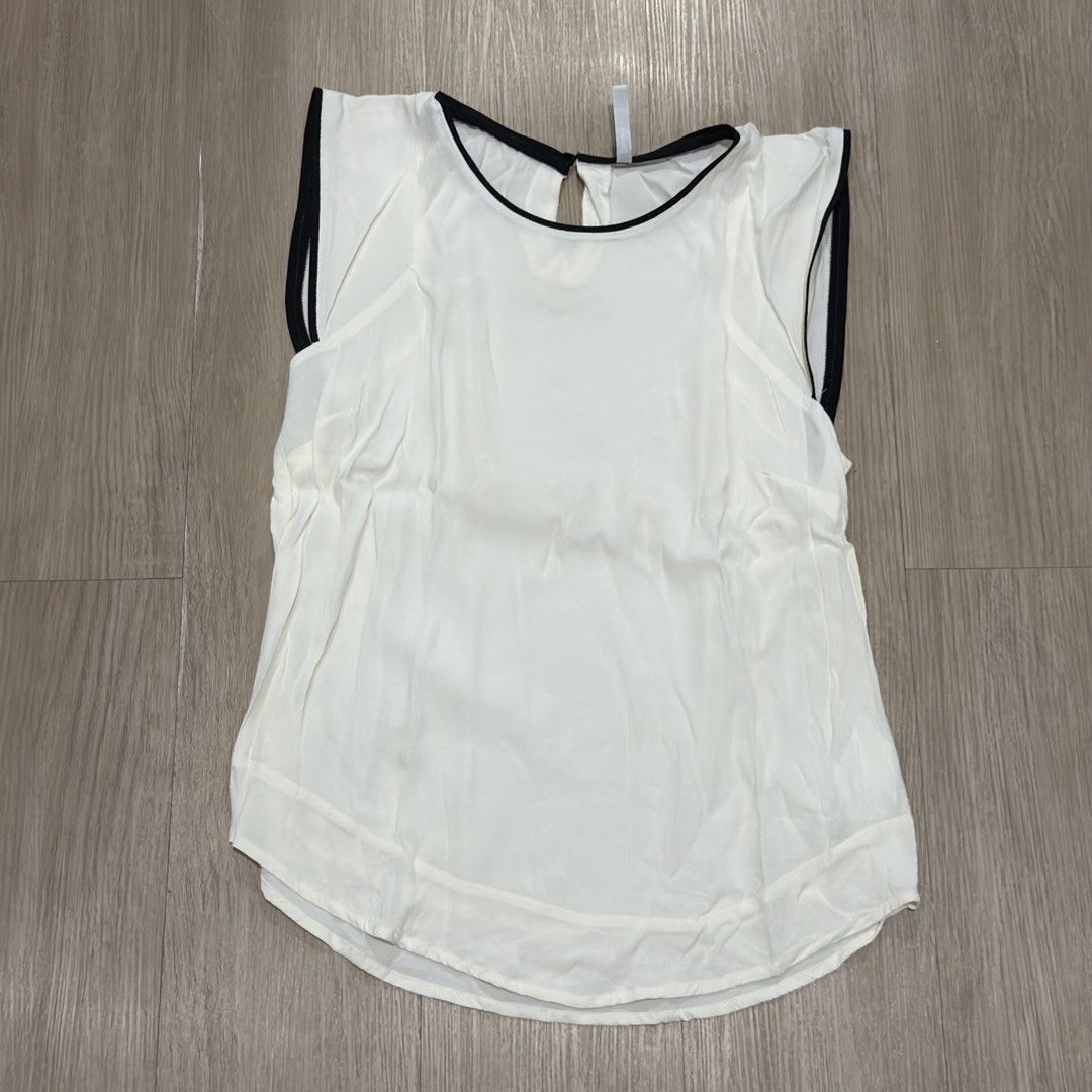 Stradivarius White Sleeveless Top with Black Trim (Category: Sleeveless) located in Manila. Submitted by sg.21 (Listing ID 1461456450, Image 1). Description: - White sleeveless top from Stradivarius - Black trim detail on neckline and armholes - Keyhole opening at the back with button closure - Classic and versatile design - Ideal for layering or wearing on its own Armpit 26” Length 23”.