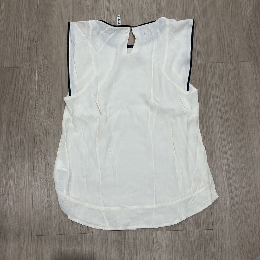 Stradivarius White Sleeveless Top with Black Trim (Category: Sleeveless) located in Manila. Submitted by sg.21 (Listing ID 1461456450, Image 2). Description: - White sleeveless top from Stradivarius - Black trim detail on neckline and armholes - Keyhole opening at the back with button closure - Classic and versatile design - Ideal for layering or wearing on its own Armpit 26” Length 23”.