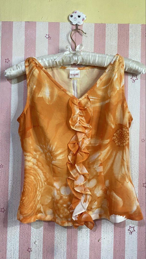 Sunset soiree vintage y2k (Category: Sleeveless) located in President Roxas. Submitted by starksandmoon_ii (Listing ID 1461395837, Image 1). Description: - Vibrant orange sleeveless top with a beautiful floral print. - Features a stylish ruffled V-neckline. - Made from lightweight and flowy fabric for comfort. - Easy to pair with skirts or pants for various outfits. - Convenient zipper closure at the back. - Perfect for both casual outings and dr