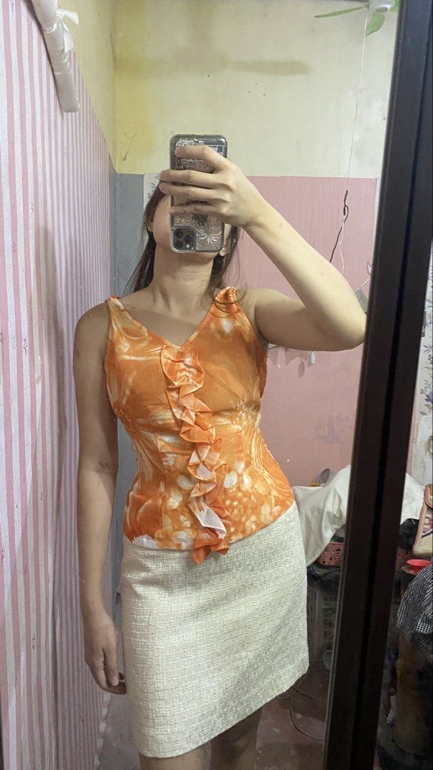 Sunset soiree vintage y2k (Category: Sleeveless) located in President Roxas. Submitted by starksandmoon_ii (Listing ID 1461395837, Image 3). Description: - Vibrant orange sleeveless top with a beautiful floral print. - Features a stylish ruffled V-neckline. - Made from lightweight and flowy fabric for comfort. - Easy to pair with skirts or pants for various outfits. - Convenient zipper closure at the back. - Perfect for both casual outings and dr