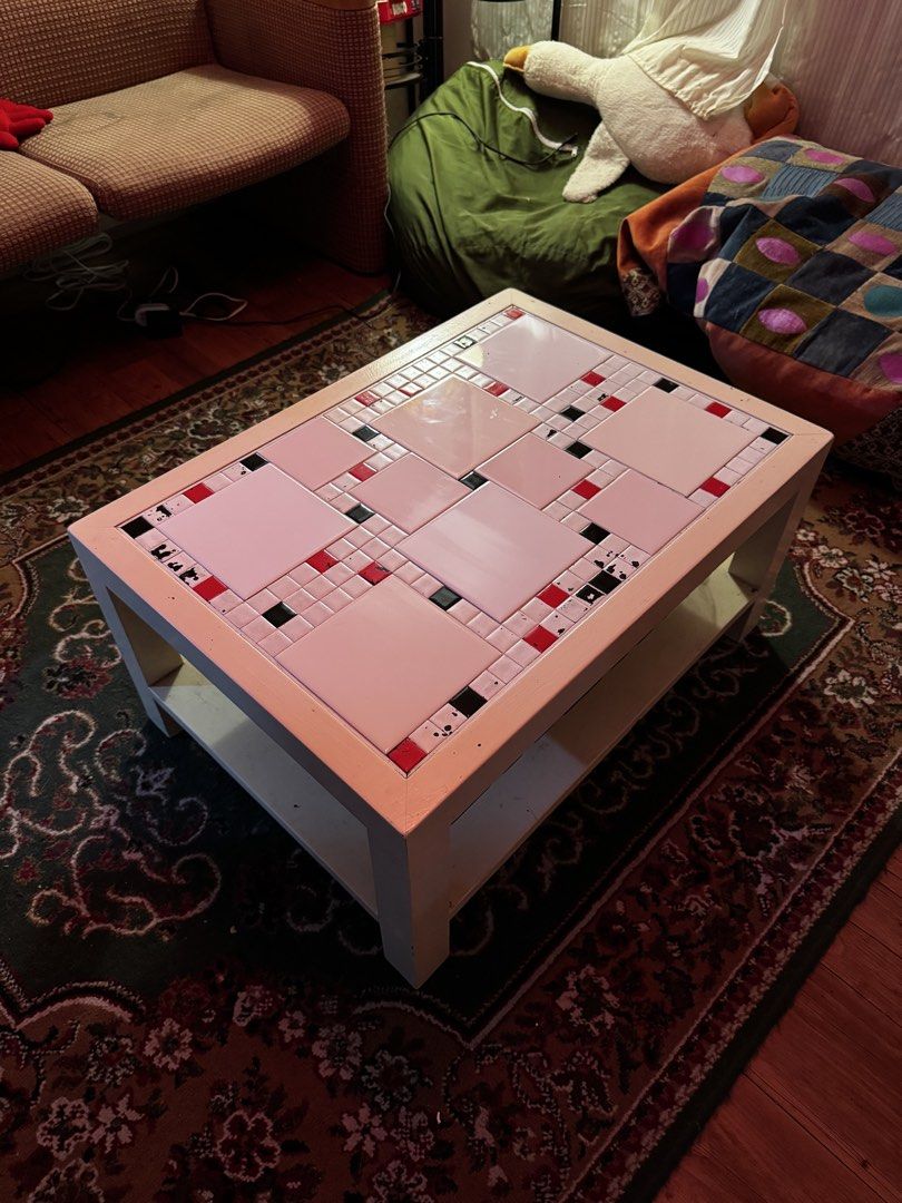 Tiled Coffee Table (Category: Tables & Sets) located in Mandaluyong City. Submitted by ka_tnko (Listing ID 1461421826, Image 3). Description: - Dimensions: W 19.75 in x L 27.50 in x H 13.25 in - unique coffee table with a vibrant tiled top - tile pattern: white, red, and black - features a convenient lower shelf with a labyrinth design pattern - white colored wood frame - ideal as a accent piece or table for game nights - solid wood State of the 