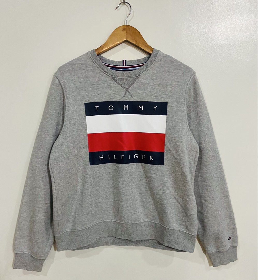 Tommy Hilfiger Grey Crewneck Sweatshirt (Category: Coats, Jackets and Outerwear) located in Manila. Submitted by thriftnijuan08 (Listing ID 1461340356, Image 1). Description: - Grey Tommy Hilfiger sweatshirt - Size: Medium (M) - Features classic Tommy flag logo on the front - Made in China - Ideal for casual everyday wear -Dimes 22/25.