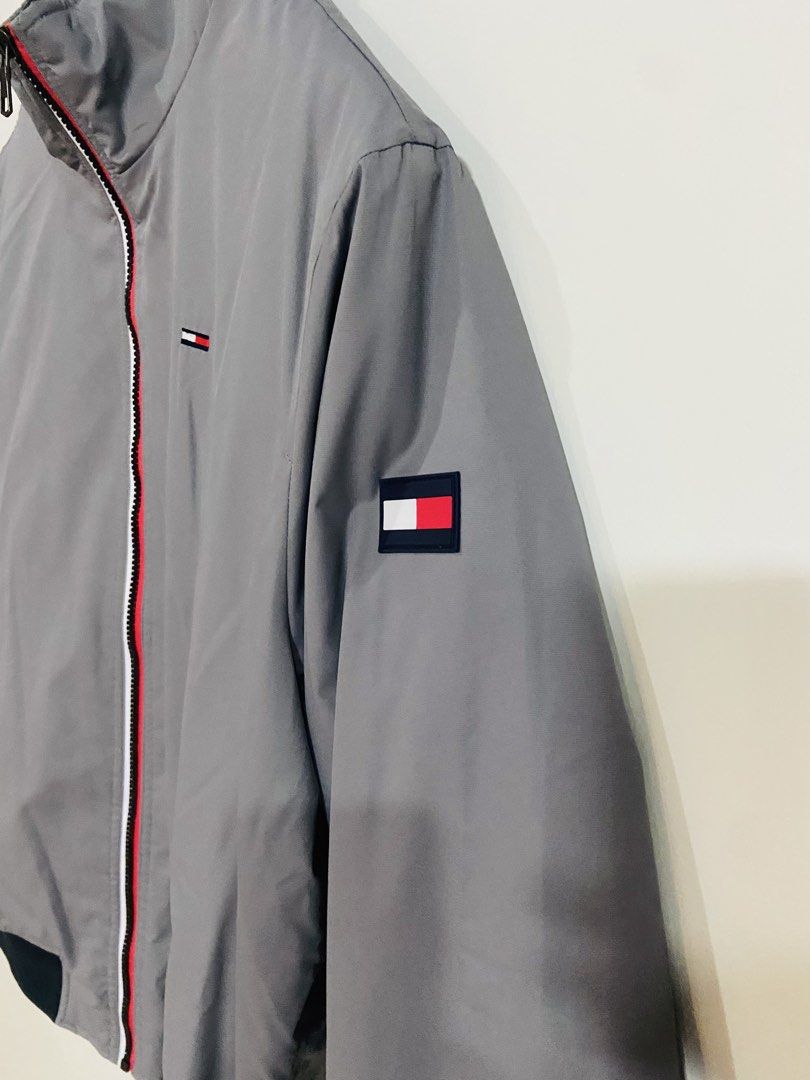 Tommy Hilfiger Grey Windbreaker Jacket Size M (Category: Coats, Jackets and Outerwear) located in Manila. Submitted by thriftnijuan08 (Listing ID 1461340196, Image 3). Description: - Grey Tommy Hilfiger jacket - Classic Tommy flag logo on chest and sleeve - Zip-up front with red and white trim - Ribbed cuffs and hem - Water and wind resistant material - Size: Medium (M) -Dimes 23/26.