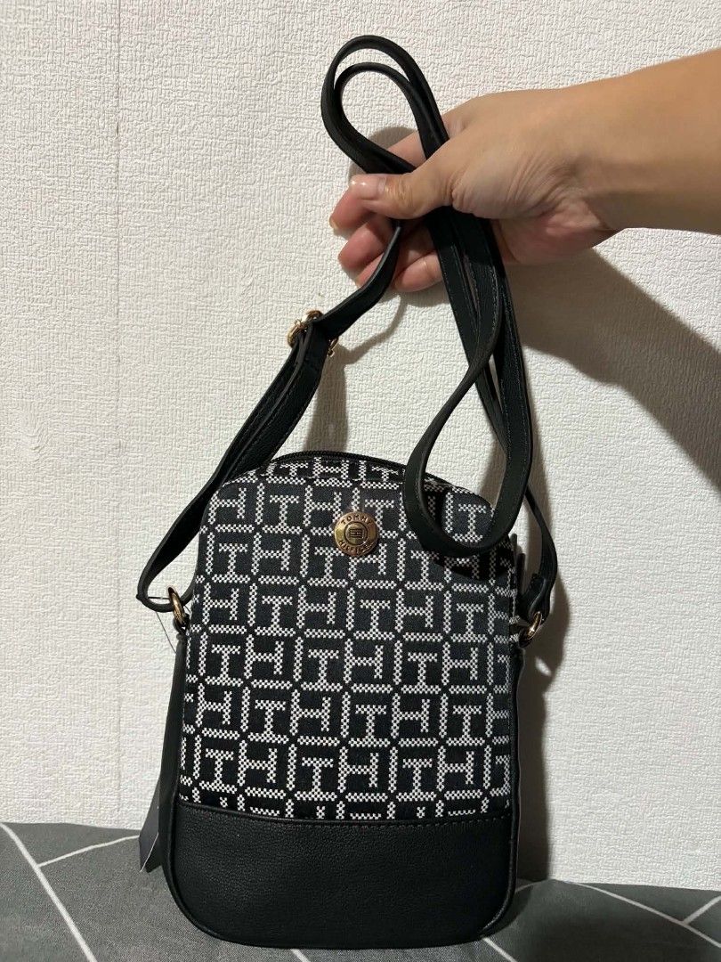 Tommy Hilfiger Monogram Crossbody Bag (Category: Cross-body Bags) located in Pateros City. Submitted by armcandystuff (Listing ID 1461456177, Image 2). Description: - Authentic Tommy Hilfiger crossbody bag - All-over monogram print in black and white - Faux leather bottom detail - Small size, perfect for essentials - Secure zip closure - Internal pocket for organization - Adjustable strap for comfortable wear - Comes with original tags.