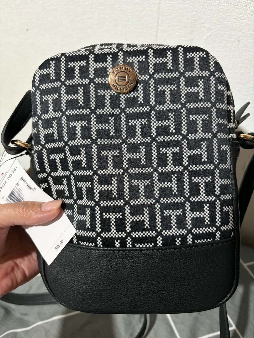 Tommy Hilfiger Monogram Crossbody Bag (Category: Cross-body Bags) located in Pateros City. Submitted by armcandystuff (Listing ID 1461456177, Image 1). Description: - Authentic Tommy Hilfiger crossbody bag - All-over monogram print in black and white - Faux leather bottom detail - Small size, perfect for essentials - Secure zip closure - Internal pocket for organization - Adjustable strap for comfortable wear - Comes with original tags.