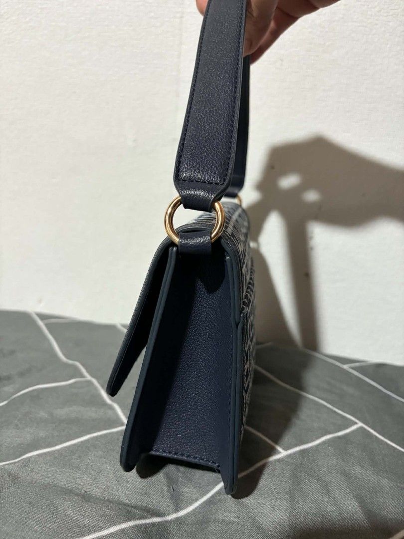 Tommy Hilfiger Monogram Shoulder Bag Navy Blue (Category: Shoulder Bags) located in Pateros City. Submitted by armcandystuff (Listing ID 1461456062, Image 2). Description: - Navy blue Tommy Hilfiger shoulder bag - Features all-over TH monogram pattern - Gold hardware detail on front closure - Includes a detachable crossbody strap - Versatile for everyday use or evening outings.