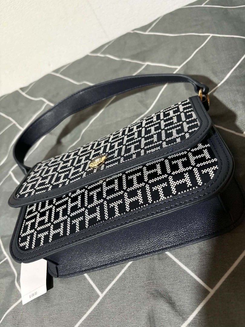 Tommy Hilfiger Monogram Shoulder Bag Navy Blue (Category: Shoulder Bags) located in Pateros City. Submitted by armcandystuff (Listing ID 1461456062, Image 3). Description: - Navy blue Tommy Hilfiger shoulder bag - Features all-over TH monogram pattern - Gold hardware detail on front closure - Includes a detachable crossbody strap - Versatile for everyday use or evening outings.
