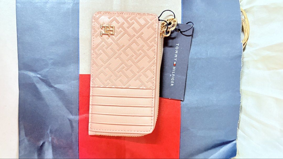 Tommy Hilfiger Pink Monogram Cardholder Wallet (Category: Wallets & Card holders) located in Pateros City. Submitted by marifernandez (Listing ID 1461400029, Image 1). Description: - Authentic Pink Tommy Hilfiger cardholder - Features iconic all-over TH monogram pattern - Includes a secure zippered compartment - Multiple card slots on the back for easy access - Comes with original tag attached - Stylish gold chain detail included - Ideal for keep