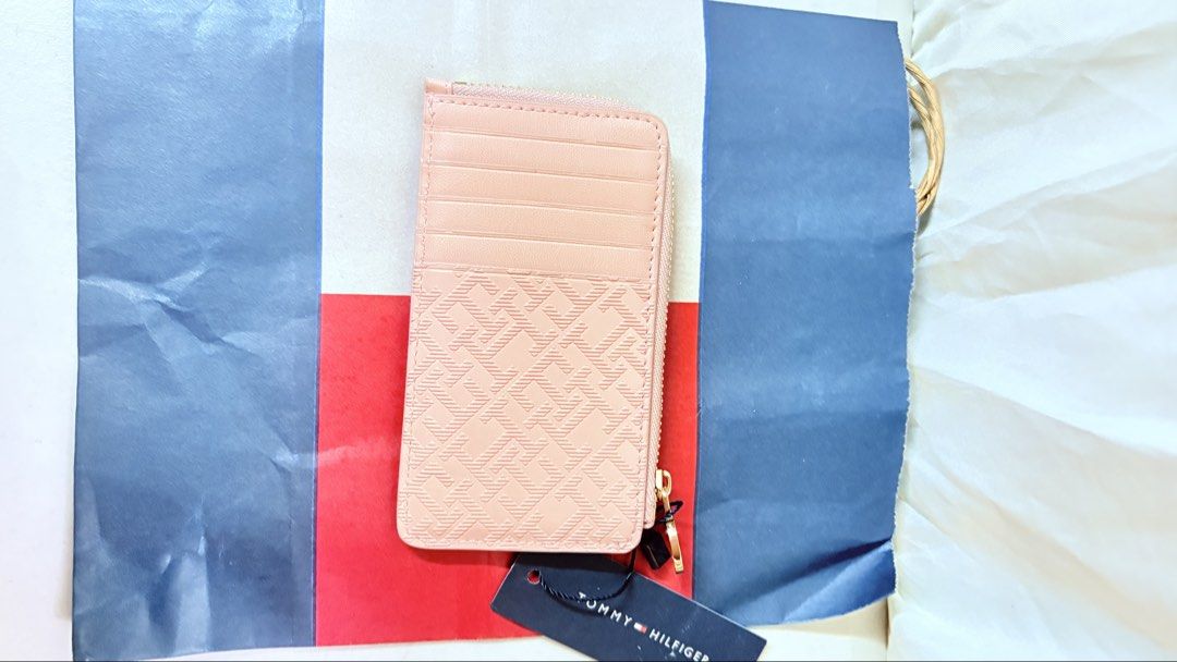 Tommy Hilfiger Pink Monogram Cardholder Wallet (Category: Wallets & Card holders) located in Pateros City. Submitted by marifernandez (Listing ID 1461400029, Image 2). Description: - Authentic Pink Tommy Hilfiger cardholder - Features iconic all-over TH monogram pattern - Includes a secure zippered compartment - Multiple card slots on the back for easy access - Comes with original tag attached - Stylish gold chain detail included - Ideal for keep