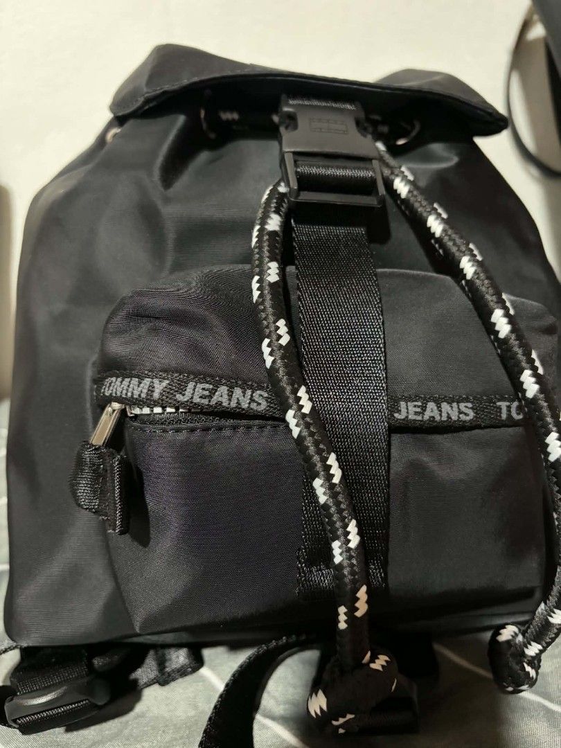Tommy Jeans Black Nylon Drawstring Backpack (Category: Backpacks) located in Pateros City. Submitted by armcandystuff (Listing ID 1461455820, Image 3). Description: - Black Tommy Jeans backpack - Durable nylon material - Secure drawstring closure with buckle strap - Convenient front zip pocket - Adjustable shoulder straps for comfort - Ideal for everyday use or travel - Interior is clean and well-maintained.
