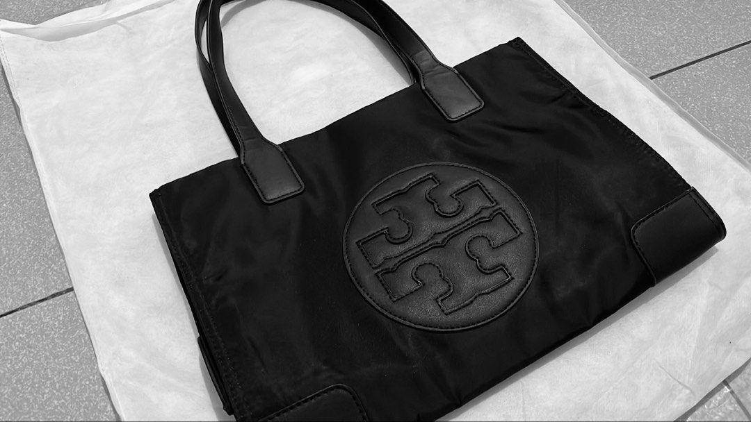 Tory Burch Black Nylon Tote Bag (Category: Luxury Bags & Wallets) located in Manila. Submitted by pickleball_paddles (Listing ID 1461441170, Image 2). Description: - Classic black Tory Burch tote bag - Durable nylon with leather trim - Iconic Tory Burch logo on the front - Spacious interior with a zippered pocket - Great for everyday use or travel - Comfortable handles for easy carrying.