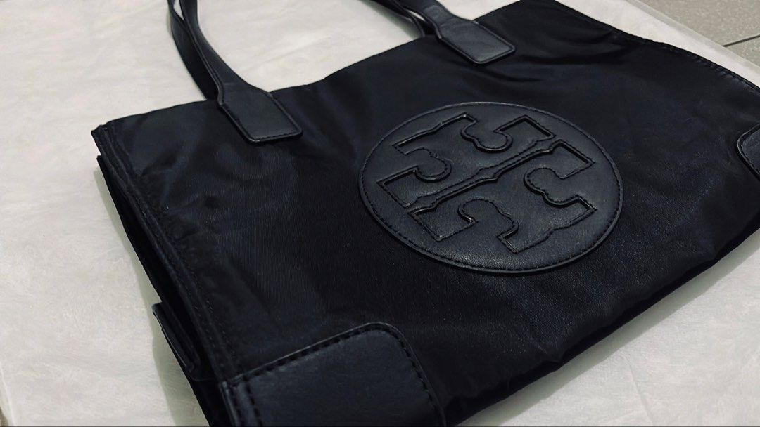 Tory Burch Black Nylon Tote Bag (Category: Luxury Bags & Wallets) located in Manila. Submitted by pickleball_paddles (Listing ID 1461441170, Image 1). Description: - Classic black Tory Burch tote bag - Durable nylon with leather trim - Iconic Tory Burch logo on the front - Spacious interior with a zippered pocket - Great for everyday use or travel - Comfortable handles for easy carrying.
