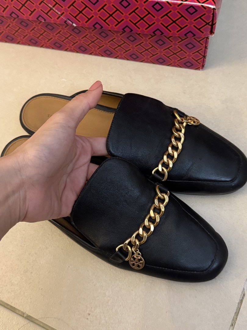 Tory Burch Mules (Category: Flats & Sandals) located in Pasay City. Submitted by shop.stylestaple (Listing ID 1461366011, Image 2). Description: - Tory Burch Black Leather Chain Mules with Box - Black leather Tory Burch mules - Gold chain detail across vamp with Tory Burch charm - Slip-on style - Soles show some wear but well taken care of - Comes with original Tory Burch box - bought in the US.