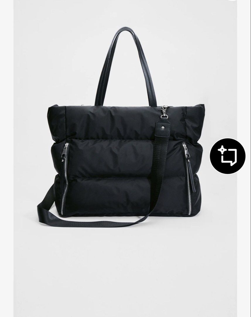 Tote bag (Category: Tote Bags) located in Pototan. Submitted by tres_190725 (Listing ID 1461512885, Image 3). Description: This item is the Stradivarius Tote Bag with Zips in black. It is a popular, lightweight utility travel shopper bag from the brand Stradivarius, constructed from a smooth nylon/polyamide fabric. It features a distinctive horizontal padded panel construction, thin twin shoulder straps, and prominent vertical zippers on the fron