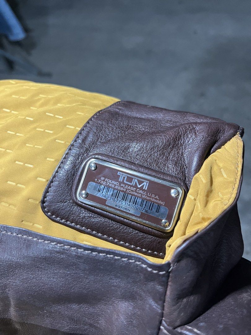 Tumi Leather Messenger Bag Brown (Category: Luxury Bags & Wallets) located in General Santos City (Dadiangas). Submitted by bornstiborns (Listing ID 1461463460, Image 3). Description: - Brand: Tumi - Material: Brown Leather - Interior: Bright Yellow Lining - Features: Multiple zippered pockets - Strap: Adjustable for comfort - Condition: Good, shows some signs of wear - Ideal for: Daily use or travel.