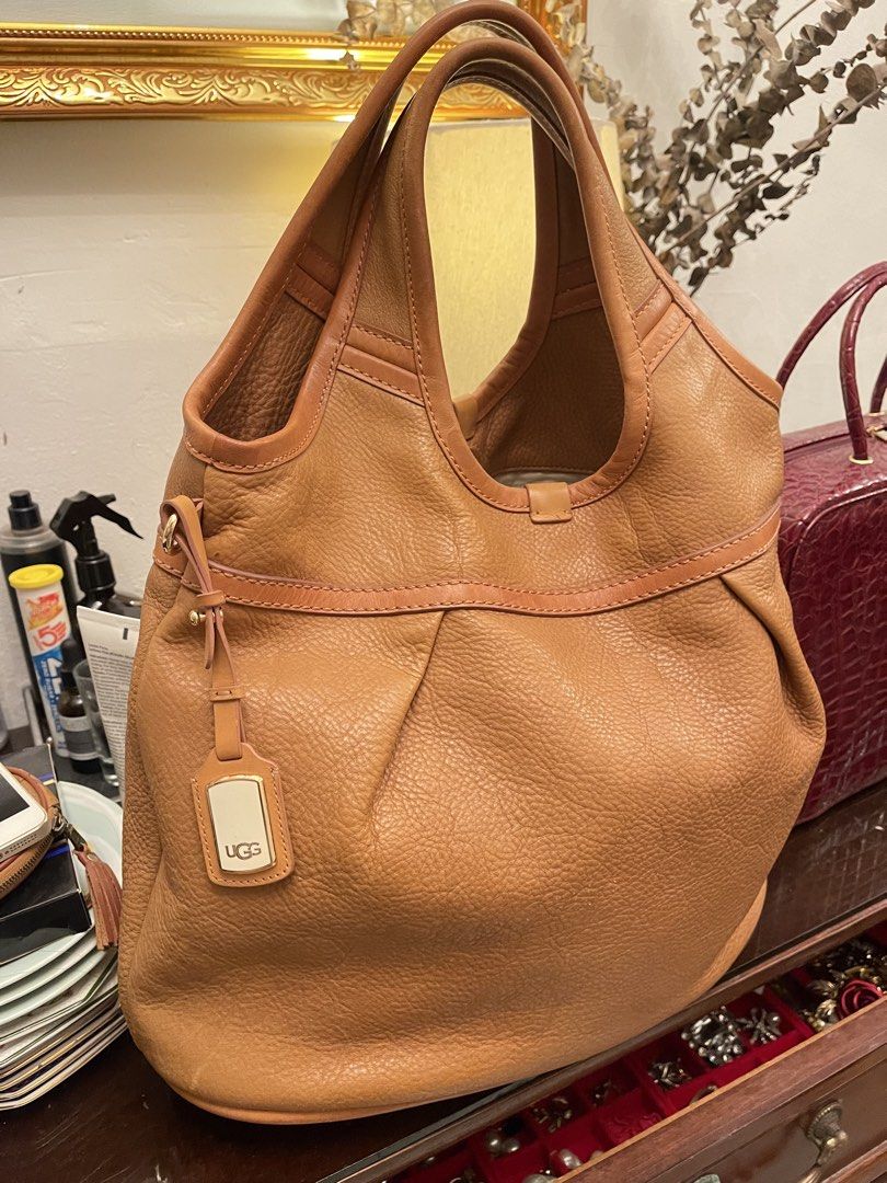 UGG Australia Leather Shoulder Bag (Category: Shoulder Bags) located in Marilao. Submitted by wardrovearchives (Listing ID 1461479239, Image 1). Description: - UGG Australia tan leather shoulder bag - Soft, pebbled leather - Main compartment with zip closure - Interior zip pocket - Gold hardware details - Includes leather logo tag - Ideal everyday bag.