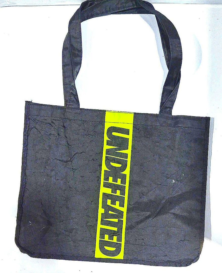 Undefeated x Starbucks Black Tote Bag (Category: Tote Bags) located in Antipolo. Submitted by saribymonica (Listing ID 1461465849, Image 1). Description: - Authentic Undefeated x Starbucks collaboration black tote bag. - Features the iconic bright yellow Undefeated logo on one side. - Showcases the Undefeated + Starbucks branding on the opposite side. - Includes a convenient small pocket inside. - Ideal for everyday use and carrying your essentia