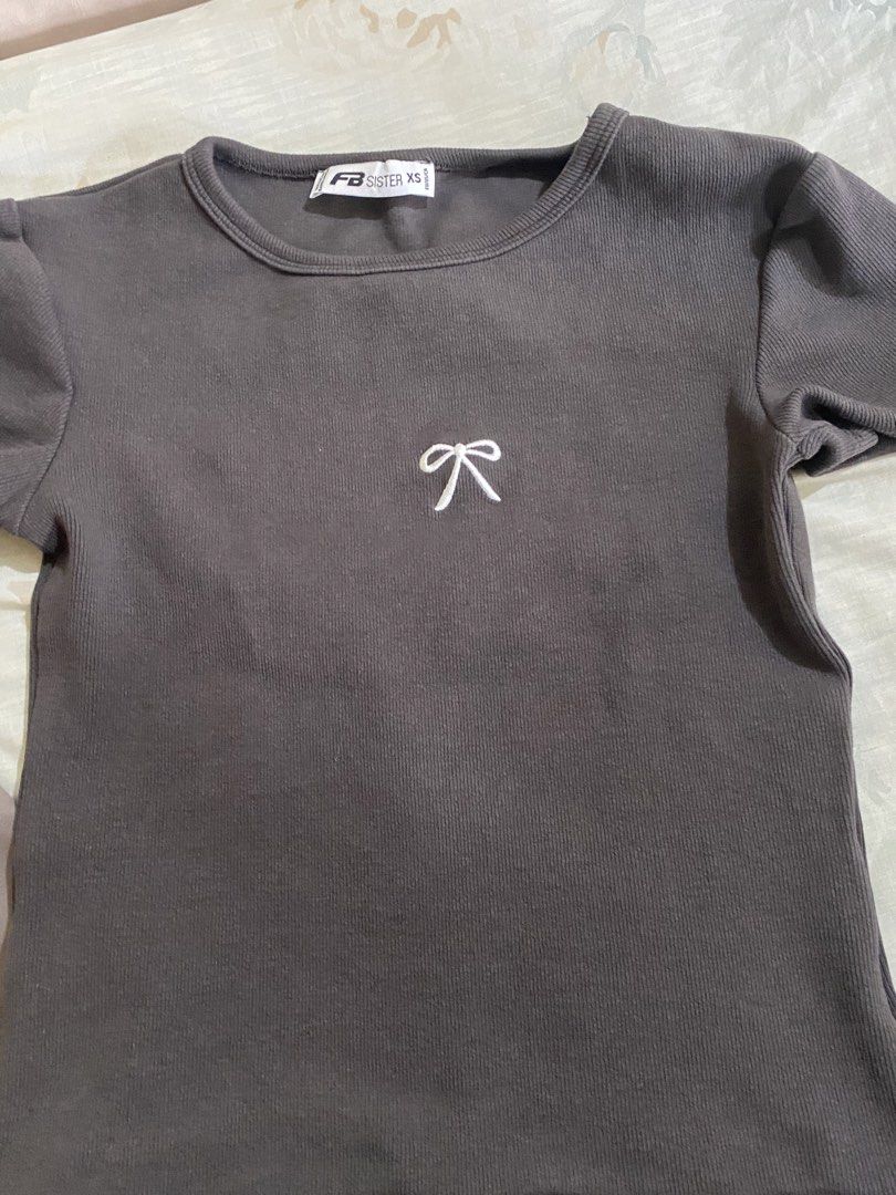 Uniqlo & FB Sister T-shirts Bundle (Category: Shirts) located in Candelaria. Submitted by xiao_z (Listing ID 1461336828, Image 3). Description: - Bundle of 2 t-shirts - Uniqlo Taupe T-shirt: Size S, 'Cool to the Touch' fabric - FB Sister Dark Grey T-shirt: Size XS, ribbed texture, small embroidered bow detail - Great for everyday wear.