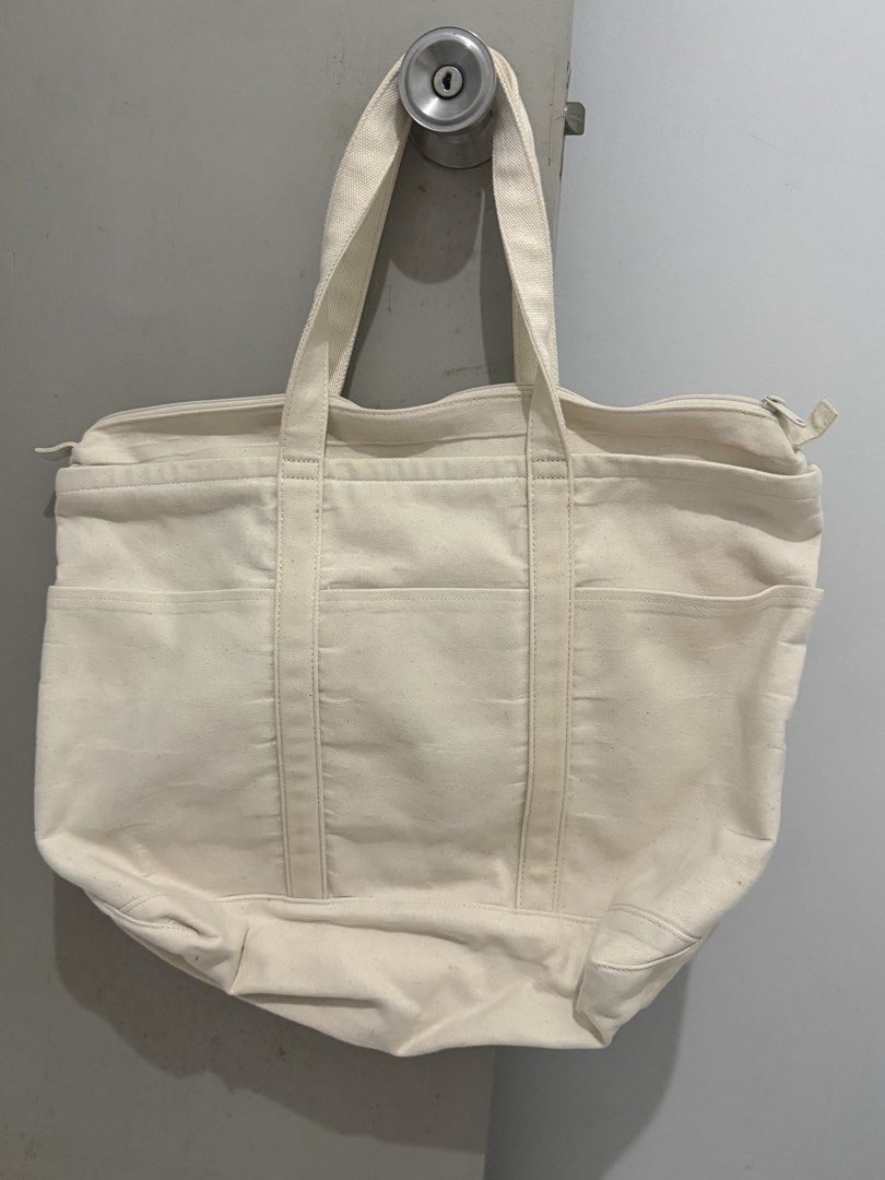 UNIQLO Canvas Tote Bag (Category: Tote Bags) located in Mandaluyong City. Submitted by trovebya (Listing ID 1461435675, Image 1). Description: - UNIQLO Cream Canvas Tote Bag - Multiple exterior pockets for easy access - Secure zippered top closure - Interior pocket for essentials - Ideal for everyday use, books, or travel - Durable cotton and polyester blend.