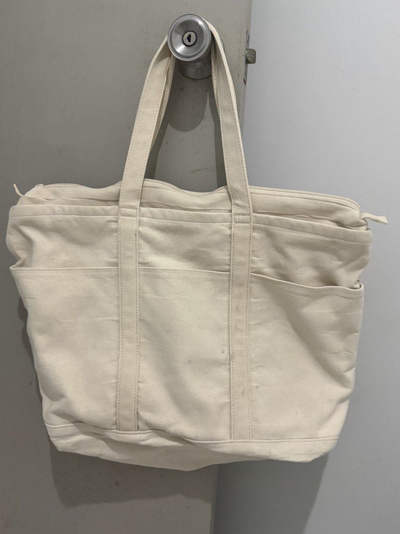 UNIQLO Canvas Tote Bag (Category: Tote Bags) located in Mandaluyong City. Submitted by trovebya (Listing ID 1461435675, Image 2). Description: - UNIQLO Cream Canvas Tote Bag - Multiple exterior pockets for easy access - Secure zippered top closure - Interior pocket for essentials - Ideal for everyday use, books, or travel - Durable cotton and polyester blend.