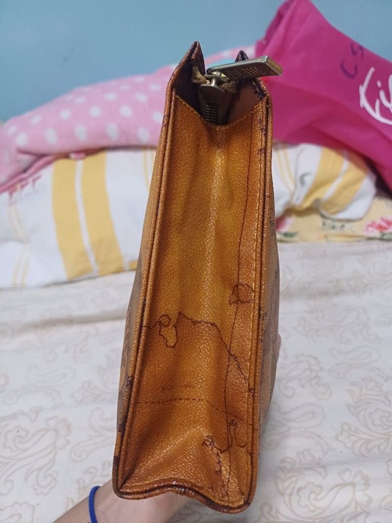 Vintage Alviero Martini Clutch (Category: Purses & Pouches) located in Naga. Submitted by mrwisethrifter (Listing ID 1461389143, Image 3). Description: - Brown leather pouch - Vintage world map print - Zipper closure - Ideal for organizing essentials - Unique item for travel enthusiasts.