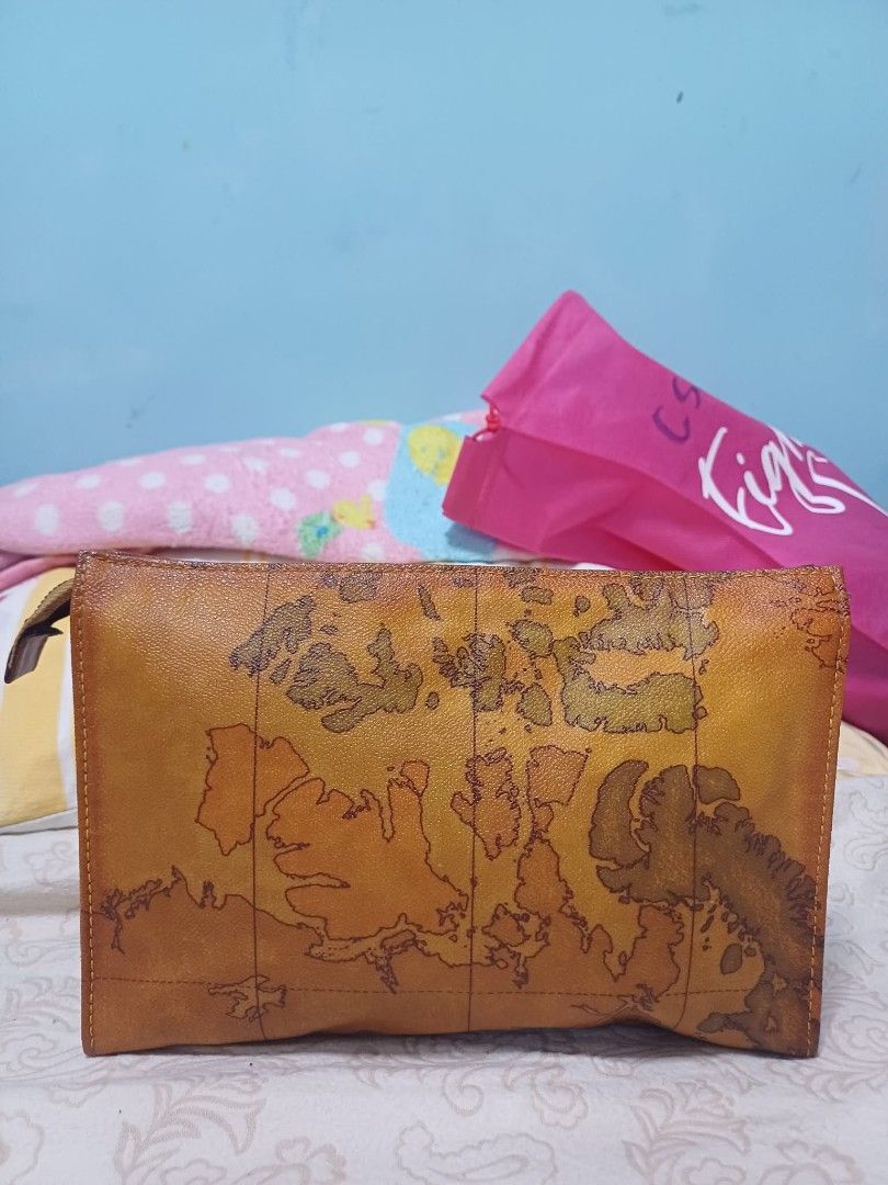 Vintage Alviero Martini Clutch (Category: Purses & Pouches) located in Naga. Submitted by mrwisethrifter (Listing ID 1461389143, Image 2). Description: - Brown leather pouch - Vintage world map print - Zipper closure - Ideal for organizing essentials - Unique item for travel enthusiasts.