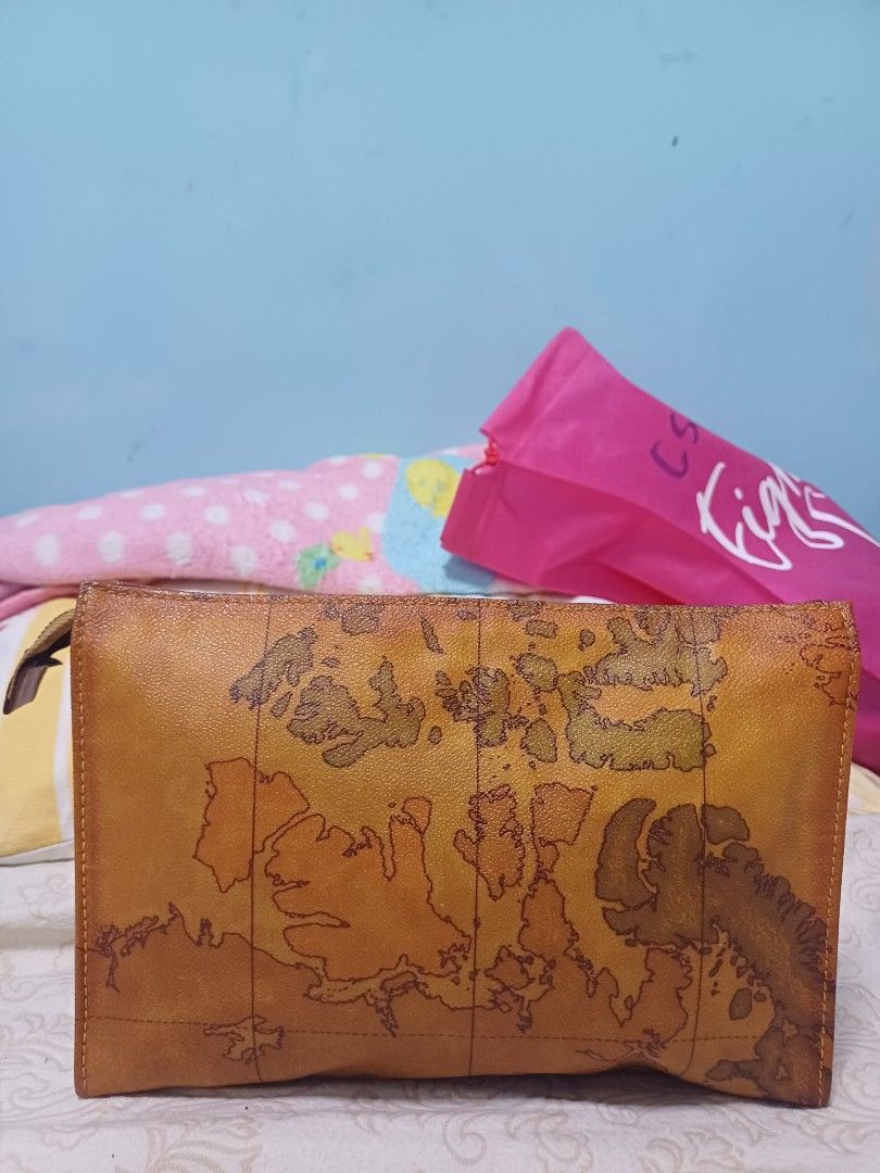 Vintage Alviero Martini Clutch (Category: Purses & Pouches) located in Naga. Submitted by mrwisethrifter (Listing ID 1461389143, Image 1). Description: - Brown leather pouch - Vintage world map print - Zipper closure - Ideal for organizing essentials - Unique item for travel enthusiasts.