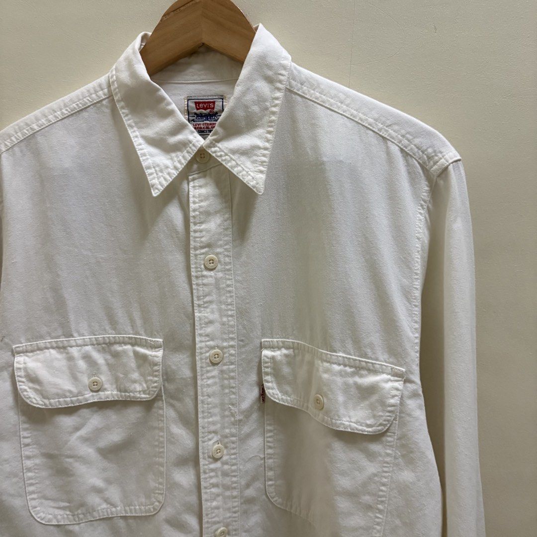 Vintage Levi’s Cream Chambray Work Shirt (Category: Tshirts & Polo Shirts ) located in Naga. Submitted by reshelled (Listing ID 1461454991, Image 2). Description: Vintage Levi’s long-sleeve work shirt in a cream/off-white color. Features a classic pointed collar, button-front closure, and two buttoned chest pockets. Made from soft 100% cotton with a slightly textured, chambray-style feel. Details * Brand: Levi’s * Tagged Size: Small (S) * Color: 