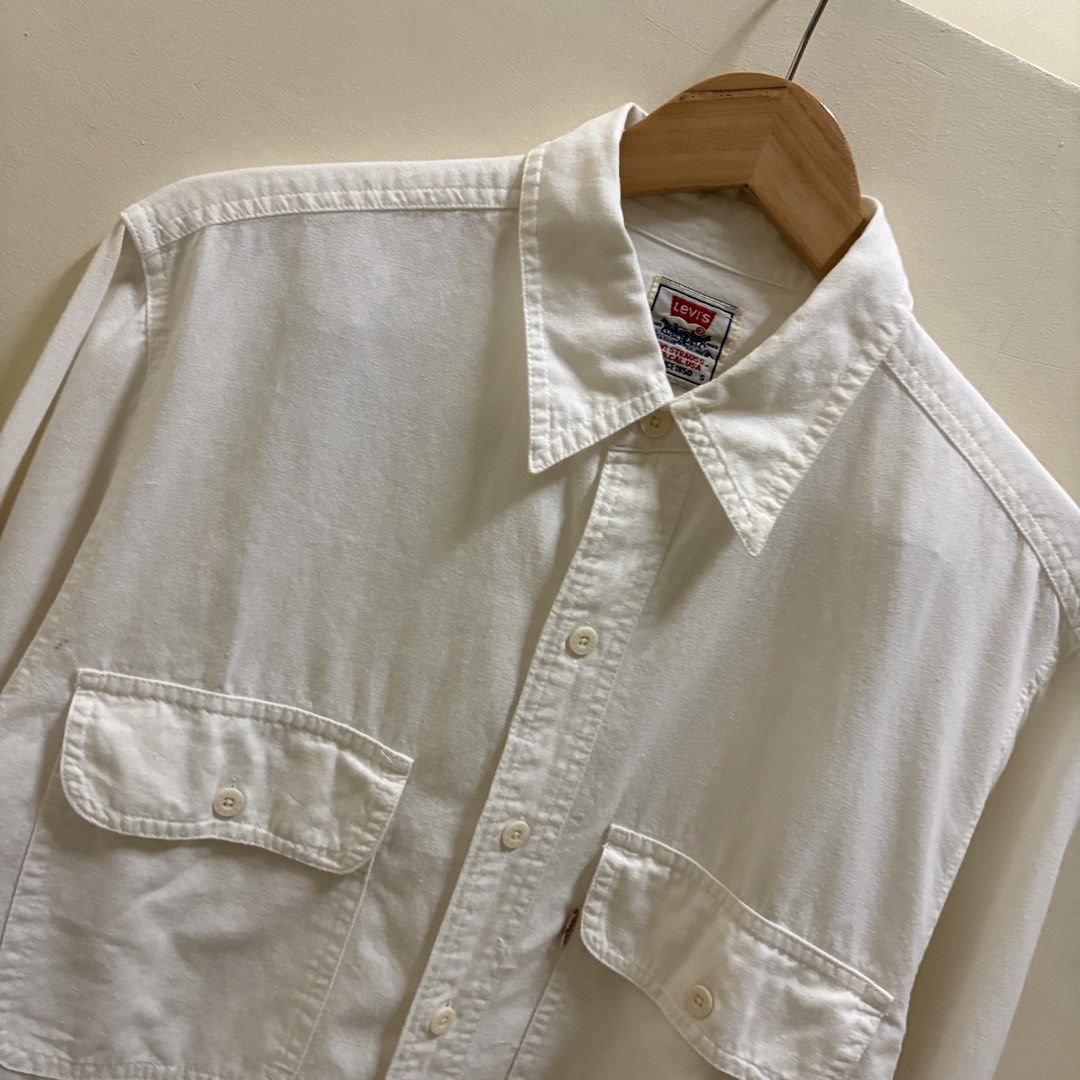 Vintage Levi’s Cream Chambray Work Shirt (Category: Tshirts & Polo Shirts ) located in Naga. Submitted by reshelled (Listing ID 1461454991, Image 3). Description: Vintage Levi’s long-sleeve work shirt in a cream/off-white color. Features a classic pointed collar, button-front closure, and two buttoned chest pockets. Made from soft 100% cotton with a slightly textured, chambray-style feel. Details * Brand: Levi’s * Tagged Size: Small (S) * Color: 