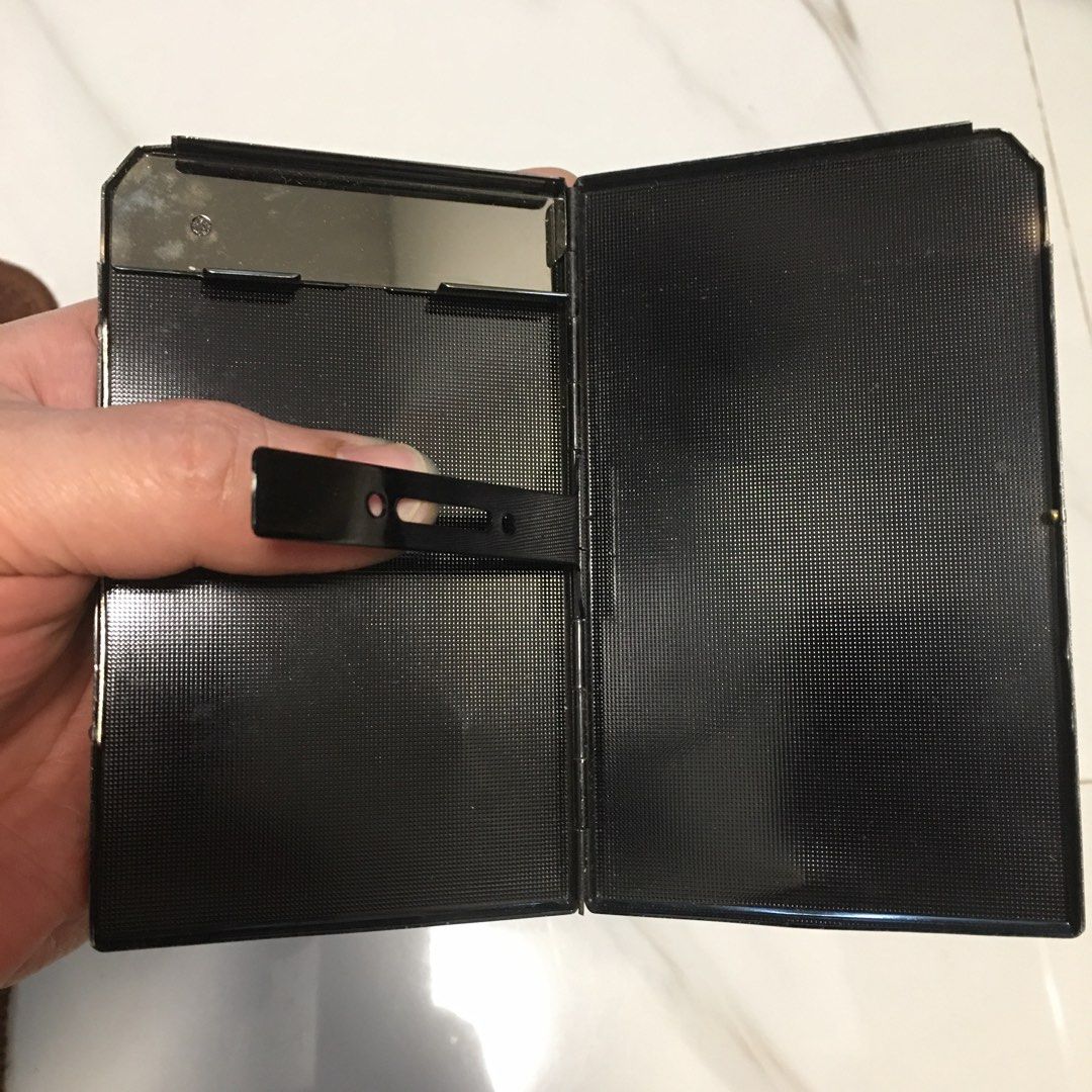 Vintage Metal Cigarette Case Holder (Category: Vintage Collectibles) located in Pasay City. Submitted by gilbertso62551 (Listing ID 1461452415, Image 3). Description: - Sleek black metal cigarette case - Textured exterior for a premium feel - Interior mirror included - Sturdy clip to hold cigarettes securely - Reliable, secure closure - Protects cigarettes from damage - Compact dimensions: approximately 3.5 inches x 3 inches when closed - As is,w