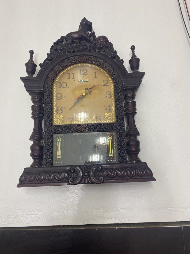 Vintage nikon clock (Category: Clocks) located in Manila. Submitted by keen.aki29 (Listing ID 1461486157, Image 1). Description: While the casing features an elaborate, antique-style Victorian silhouette with a horse emblem at the top, it is actually a vintage 1980s or 1990s quartz wall clock made out of molded plastic. The "NIKON" branding on the face denotes a budget mass-produced clock line common in Southeast Asian markets during that era, ra